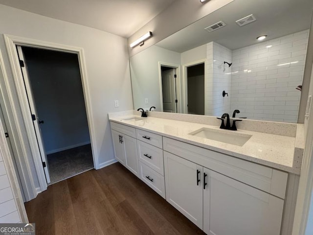 bathroom with vanity, wood-type flooring, and tiled shower