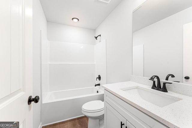 full bathroom with hardwood / wood-style flooring, vanity,  shower combination, and toilet