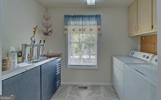 laundry area featuring separate washer and dryer and cabinets