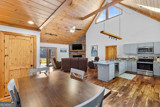 dining area featuring high vaulted ceiling, dark hardwood / wood-style floors, ceiling fan, beamed ceiling, and wood ceiling