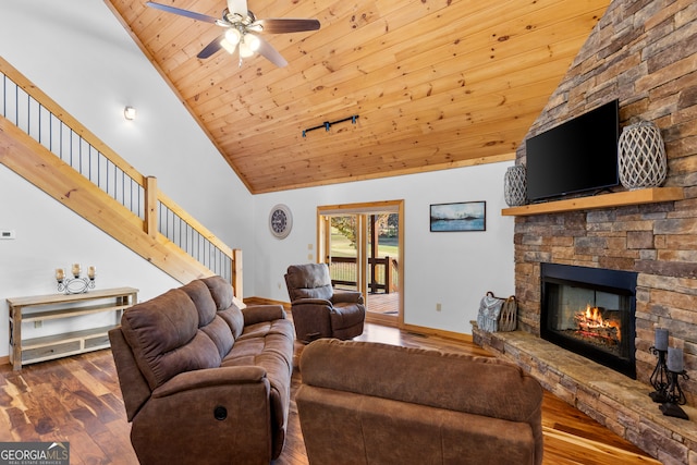 living room featuring hardwood / wood-style floors, a stone fireplace, wood ceiling, and high vaulted ceiling