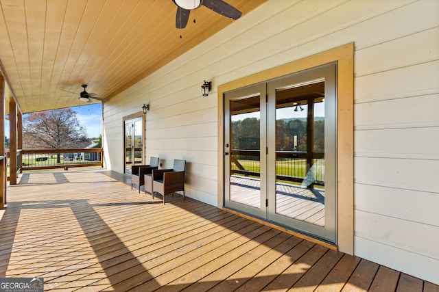 wooden deck with ceiling fan and french doors