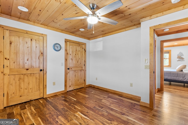 unfurnished bedroom featuring ceiling fan, dark hardwood / wood-style flooring, and wooden ceiling