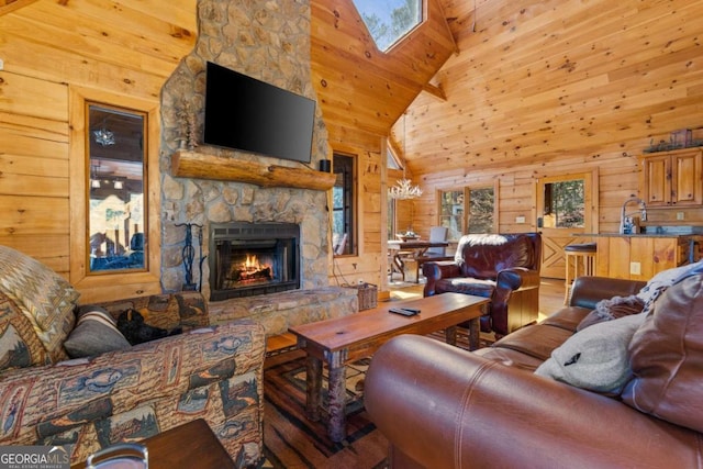 living room with a fireplace, high vaulted ceiling, a skylight, and wooden walls