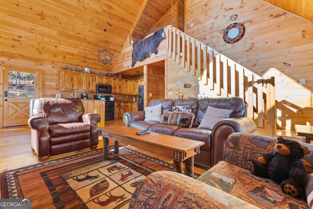 living room featuring high vaulted ceiling, light hardwood / wood-style flooring, and wooden walls