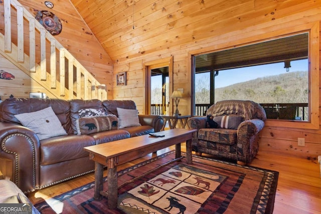 living room featuring wooden walls, vaulted ceiling, wood ceiling, and hardwood / wood-style flooring