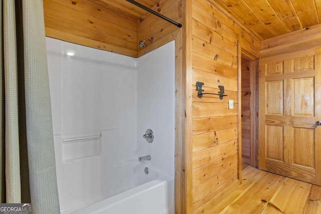 bathroom with wooden walls, shower / tub combo with curtain, wooden ceiling, and hardwood / wood-style flooring