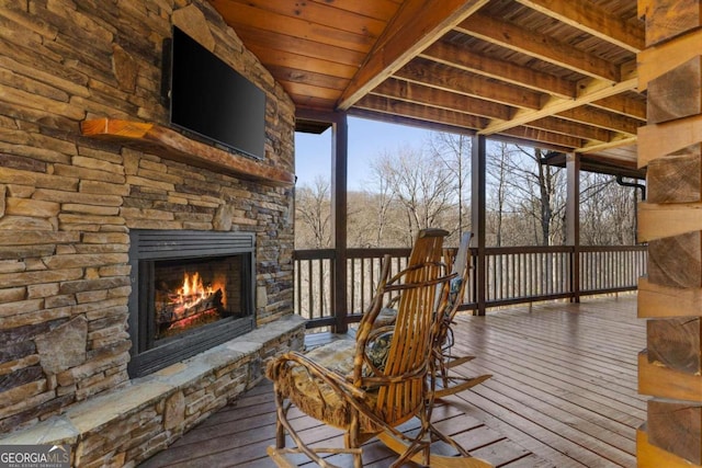 wooden terrace featuring an outdoor stone fireplace