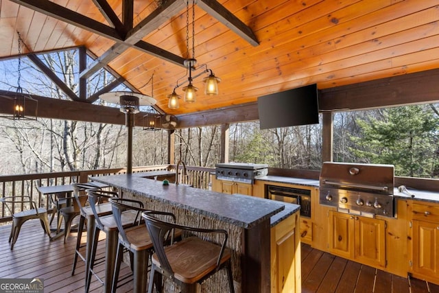 wooden terrace featuring exterior kitchen, area for grilling, and exterior bar