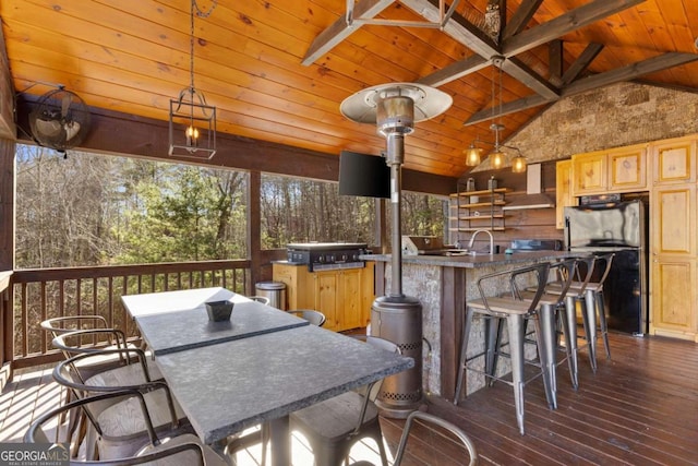 wooden deck with area for grilling, an outdoor wet bar, a grill, and ceiling fan