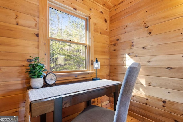 living area featuring a healthy amount of sunlight and wood walls