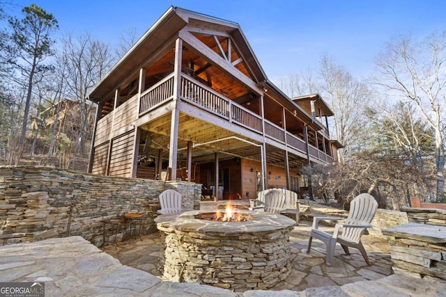 rear view of house with an outdoor fire pit and a patio area