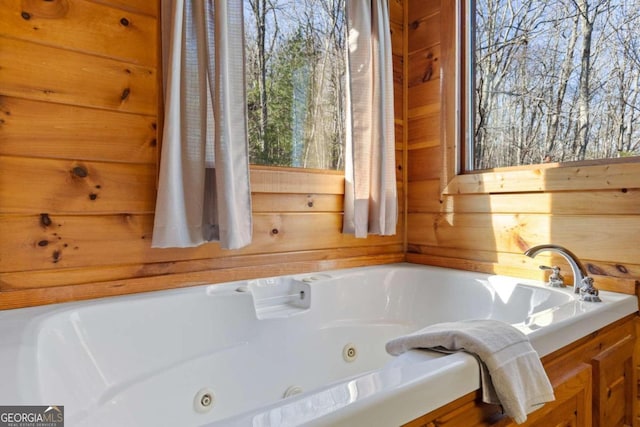 bathroom featuring wooden walls and a bathing tub