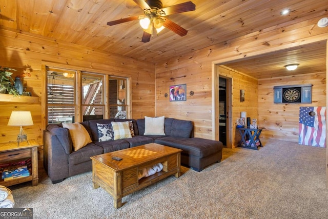 carpeted living room featuring wood walls, wooden ceiling, and ceiling fan