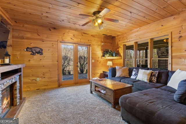 living room with wood walls, carpet floors, wooden ceiling, and plenty of natural light