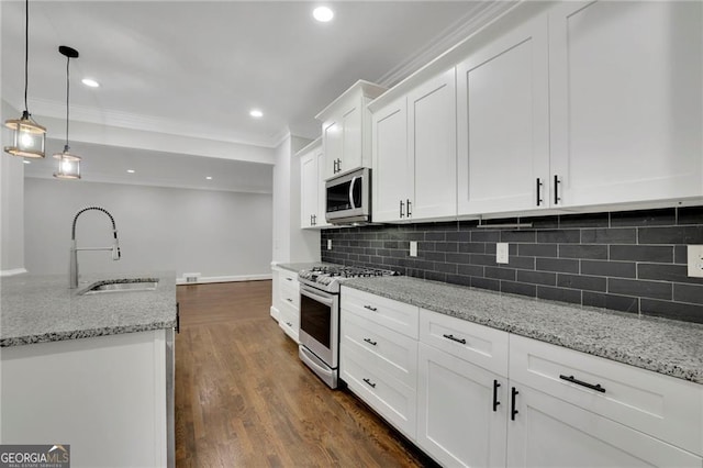 kitchen with sink, hanging light fixtures, stainless steel appliances, white cabinets, and light stone counters