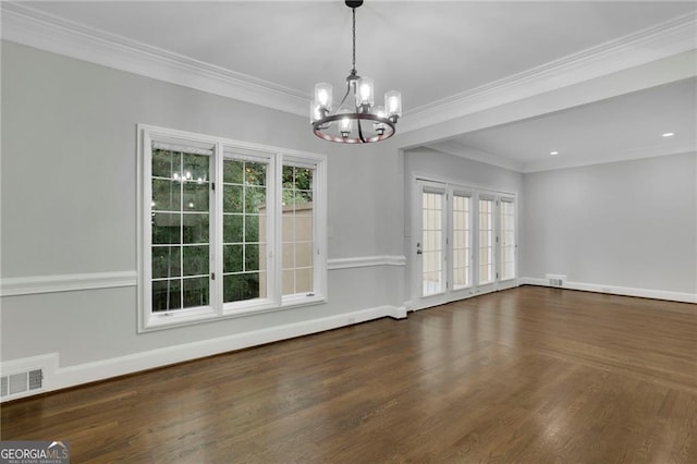 unfurnished room with crown molding, dark hardwood / wood-style floors, and an inviting chandelier