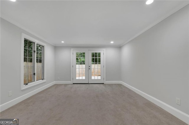 carpeted spare room featuring french doors and crown molding