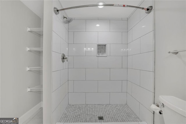 bathroom featuring toilet and tiled shower