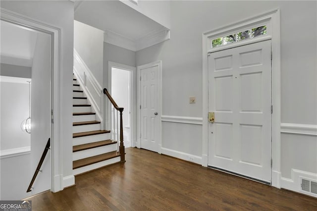 foyer featuring dark wood-type flooring and ornamental molding