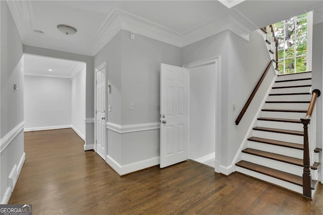 entryway with dark wood-type flooring and crown molding