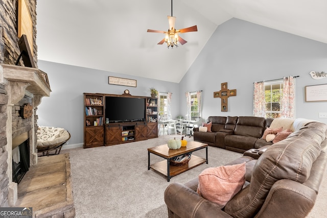 living room featuring light carpet, a stone fireplace, high vaulted ceiling, and ceiling fan