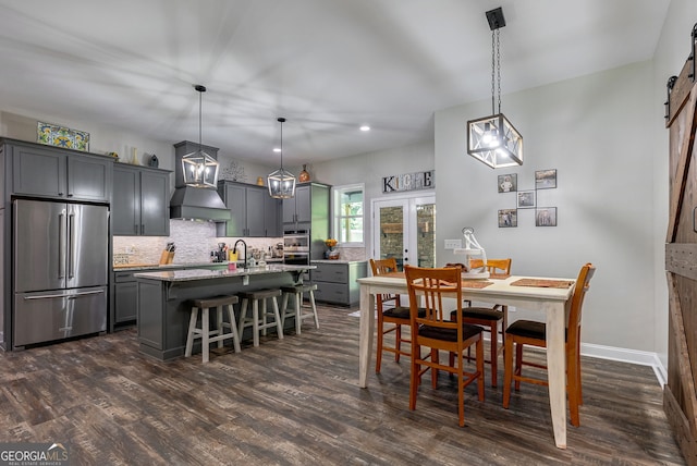 dining room featuring french doors, sink, dark hardwood / wood-style floors, and a barn door