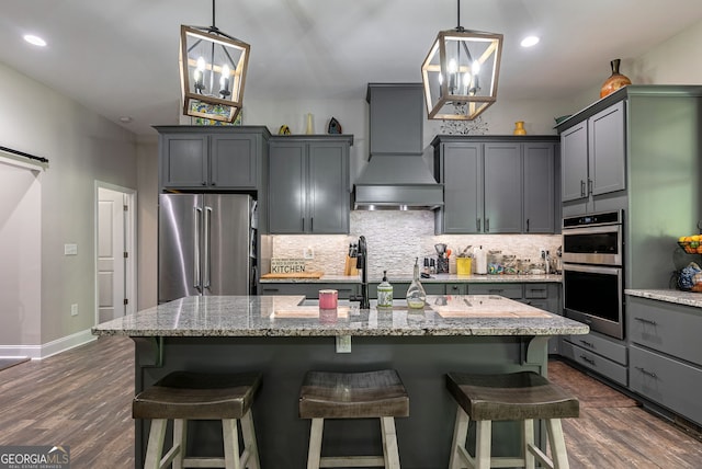 kitchen featuring premium range hood, stainless steel appliances, light stone countertops, and dark wood-type flooring