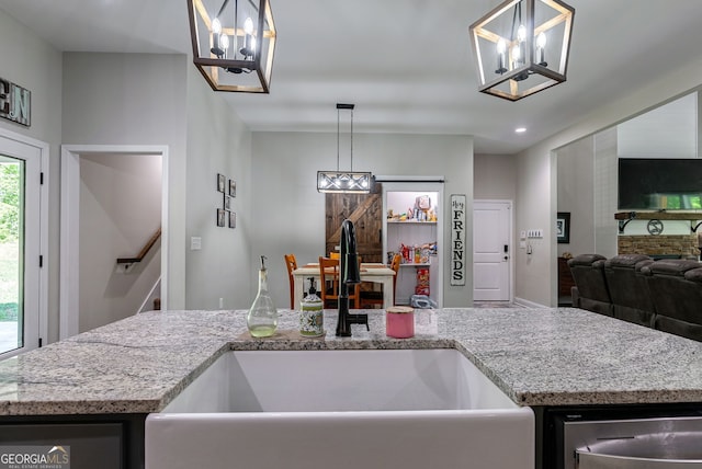 kitchen featuring a kitchen island with sink, sink, pendant lighting, and dishwasher