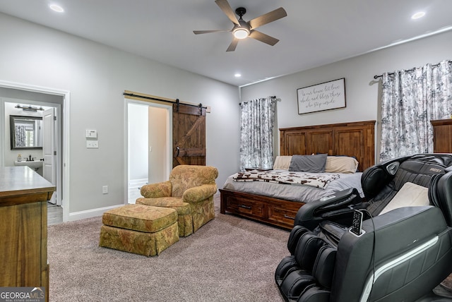 carpeted bedroom featuring connected bathroom, a barn door, and ceiling fan