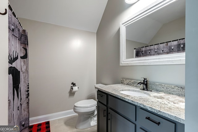 bathroom featuring tile patterned floors, toilet, vaulted ceiling, and vanity