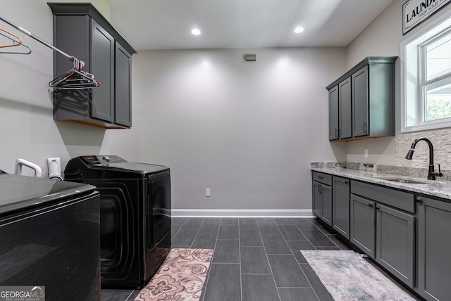 washroom with washer and dryer, sink, and cabinets