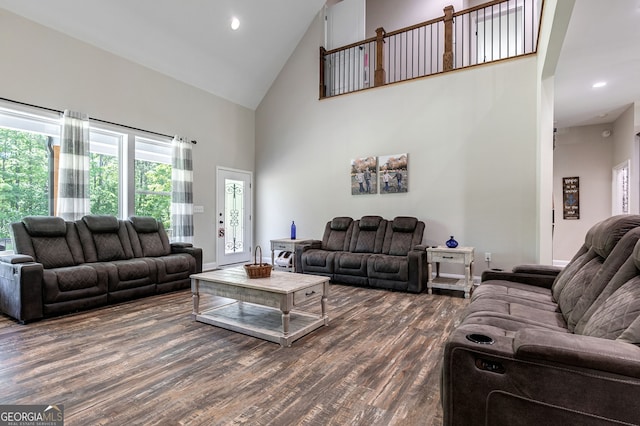 living room with dark wood-type flooring and high vaulted ceiling