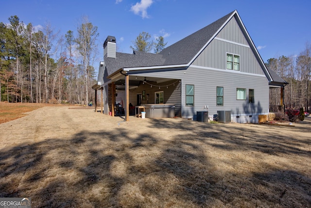 view of side of home featuring a hot tub and central AC unit