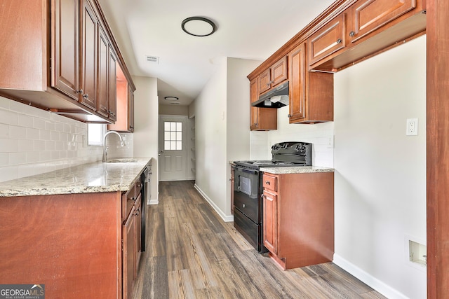 kitchen with sink, decorative backsplash, black / electric stove, light stone counters, and dark wood-type flooring