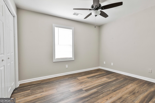 unfurnished bedroom with a closet, ceiling fan, and dark hardwood / wood-style flooring