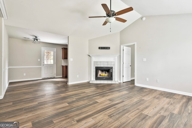 unfurnished living room featuring dark wood-type flooring, high vaulted ceiling, a tile fireplace, and ceiling fan