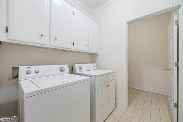 washroom featuring crown molding, washer and clothes dryer, light tile patterned floors, and cabinets