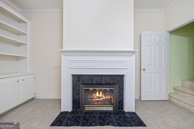 interior details with ornamental molding, carpet, and a tile fireplace