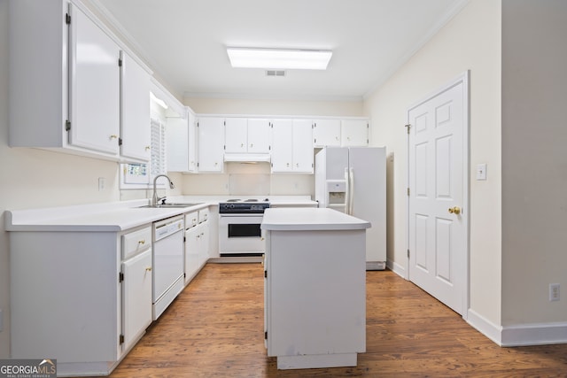 kitchen with hardwood / wood-style floors, white cabinets, sink, a center island, and white appliances