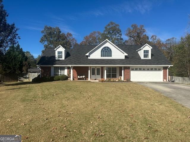 cape cod home with a garage and a front lawn