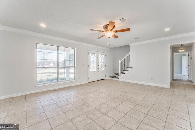 foyer with ornamental molding and a ceiling fan