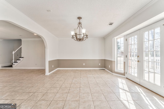spare room with visible vents, crown molding, arched walkways, and light tile patterned floors