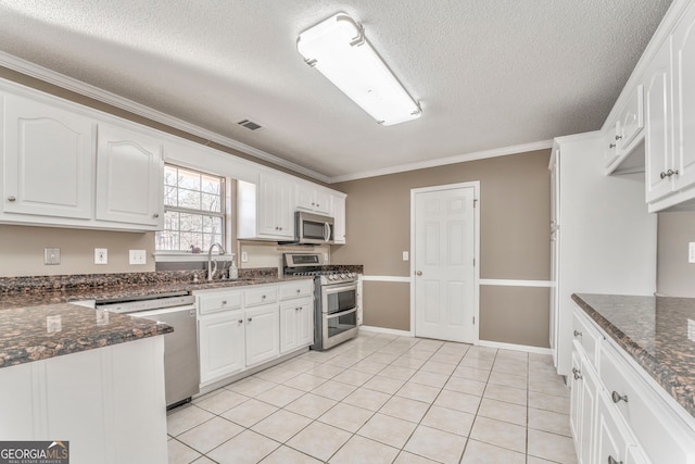 kitchen featuring white cabinetry, light tile patterned floors, stainless steel appliances, a sink, and visible vents