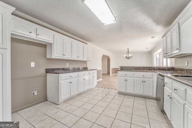 kitchen featuring white cabinets, a chandelier, a peninsula, arched walkways, and stainless steel dishwasher