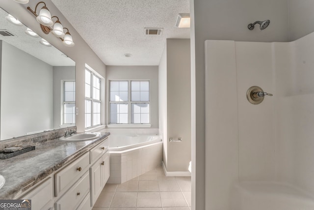 bathroom featuring a textured ceiling, tile patterned floors, a sink, visible vents, and a bath