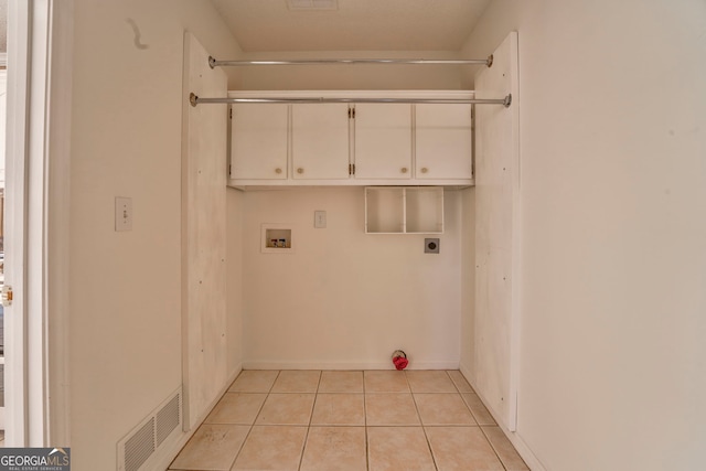 washroom featuring hookup for an electric dryer, light tile patterned floors, hookup for a washing machine, visible vents, and cabinet space