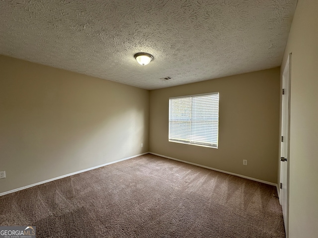 carpeted spare room featuring a textured ceiling