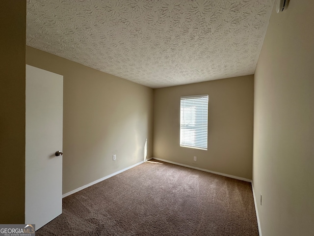 empty room featuring a textured ceiling and carpet floors