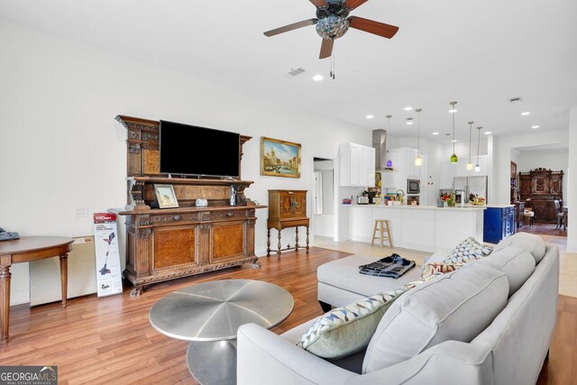 living room featuring dark hardwood / wood-style floors, plenty of natural light, and ceiling fan